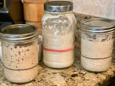 three mason jars sitting on top of a counter