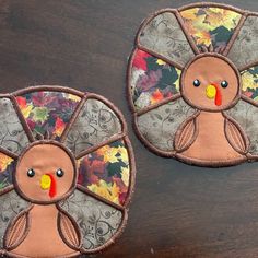 two handmade turkey coasters sitting on top of a wooden table next to each other