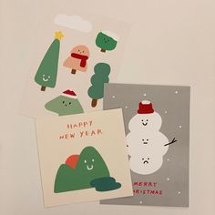 three christmas cards with snowmen and trees on them, one is happy new year