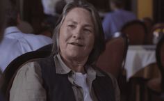 an older woman sitting in a chair at a restaurant