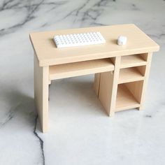 a small wooden desk with a keyboard and mouse sitting on it's top shelf