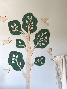 a wooden tree with birds on it in a room next to a white curtain and wall