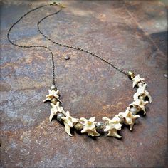 "-This unisex necklace is an interesting combination of graduated weasel vertebrae and handmade Ethiopian silver and brass beads. -The necklace is 27\" in total length, and can easily be layered with other longer or shorter necklaces. -Beads and vertebrae are strung onto an antique-brass chain, and finished with a matching lobster clasp. -No animals were harvested to make this necklace. -Designed and handmade in South Pasadena, CA. Check out more of our necklaces here: https://www.etsy.com/shop/ Unique Adjustable Bone-colored Necklace, Unique Adjustable Bone Colored Necklace, Unique Adjustable Bone Necklace, Handmade Bone Color Necklace For Gift, Unique Handmade Bone-colored Necklace, Handmade Bone Color Necklace Gift, Handmade Bone-colored Unique Necklace, Unique Handmade Bone Necklace, Taxidermy Jewelry