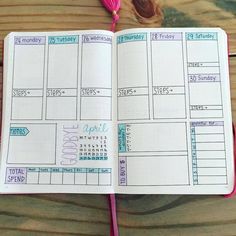 an open planner book sitting on top of a wooden table