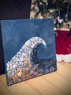 a painting on a wooden table with a christmas tree in the background and a surfboard painted on it