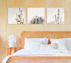 a bed with white pillows and two pictures on the wall above it in a bedroom