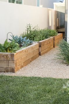 an outdoor garden with wooden planters and grass