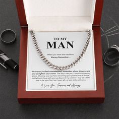 a box that has a chain on it and some rings in front of it with the words to my man written on it