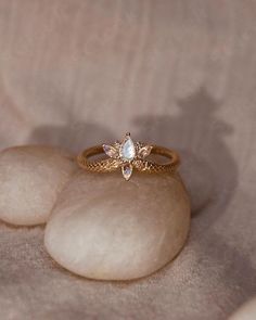 a close up of a ring on top of some rocks with stones in the background