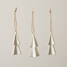 three white ceramic ornaments hanging from strings