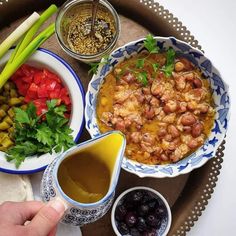 a tray filled with different types of food on top of a wooden table next to dipping sauce