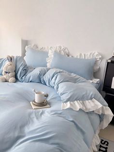 a blue comforter with ruffles on it and a coffee cup in the middle