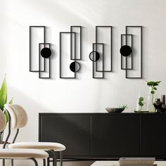 a modern living room with black and white furniture, art work on the wall and potted plants in vases