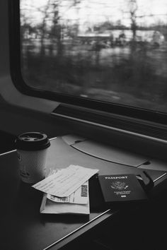 a cup of coffee sitting on top of a table next to a window