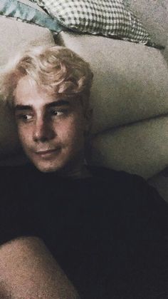 a man with blonde hair sitting on a couch