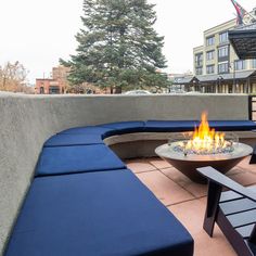 a fire pit sitting on top of a patio next to a blue couch and table