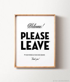 a black and white poster with the words welcome please leave on it, hanging in a wooden frame