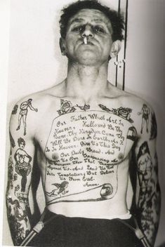 an old black and white photo of a man with tattoos on his chest