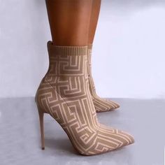 a woman's legs wearing high heeled shoes with an intricate design on them