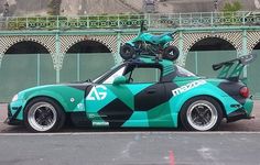 a green and black car with a bike on top