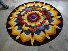 a colorful circular rug is on the floor in front of a person standing next to it