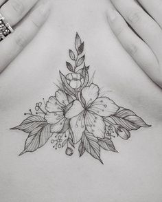 a woman's stomach with flowers and leaves on her side, in front of her chest