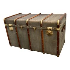 an old trunk is sitting on the floor with brass hardware and leather trimmings