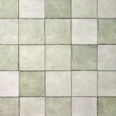 a white tiled wall with green and gray tiles