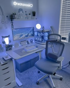 a computer desk topped with a monitor and keyboard next to a window covered in blue light