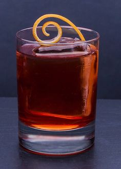 an orange slice sitting on top of a glass filled with liquid