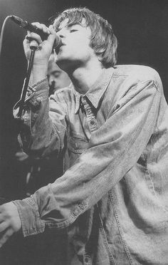 black and white photograph of a man singing into a microphone