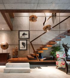 a living room filled with furniture next to a stair case and painting on the wall