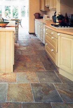 a kitchen filled with lots of wooden cabinets and counter top next to an open door