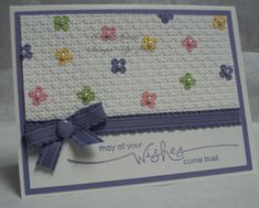 a close up of a greeting card with flowers on the front and blue ribbon at the bottom