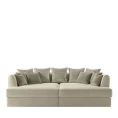 a white couch with many pillows on it's back and side ends, against a white background