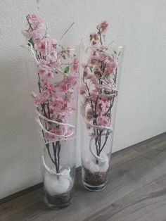 two clear vases with pink flowers in them