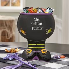 the gollims family candy bowl sits on a checkered tablecloth in front of an assortment of halloween candies