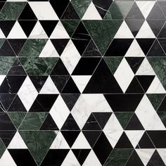 a black and white tiled wall with triangulars on the bottom, in different colors