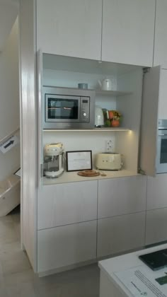 a kitchen area with microwave, toaster oven and other items on the counter top