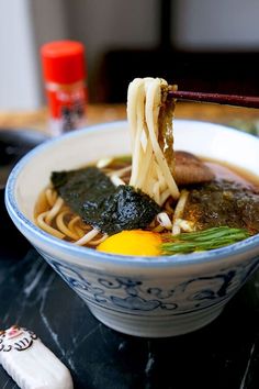 a bowl of ramen with chopsticks sticking out of it