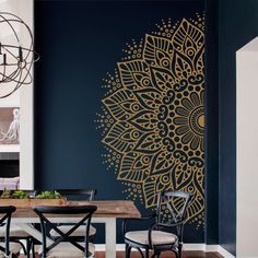 a dining room table with chairs and a large wall mural on the wall behind it