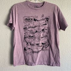 a purple t - shirt hanging on a white wall