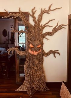 a fake tree that has been carved into the shape of a scary face on it