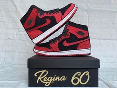 a pair of red and black sneakers sitting on top of a box