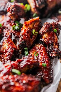 chicken wings covered in bbq sauce and garnished with scallions