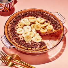 there is a pie with bananas and chocolate on the top, next to a fork