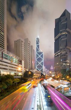 the city is busy with traffic and skyscrapers in the background at night, as well as long exposure