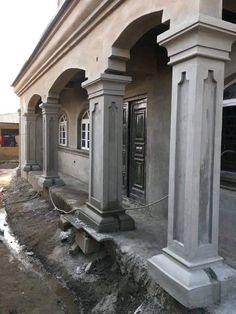 an old building is being renovated with concrete pillars and columns on the side of it