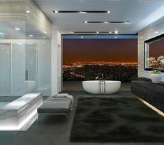 a bathroom with a tub, sink and large window overlooking the city at night time