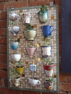 there are many cups and vases on the wall